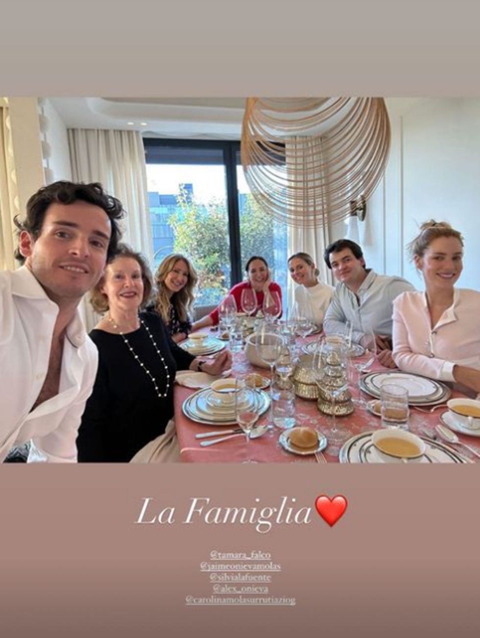 a group of people sitting around a table with food and drinks