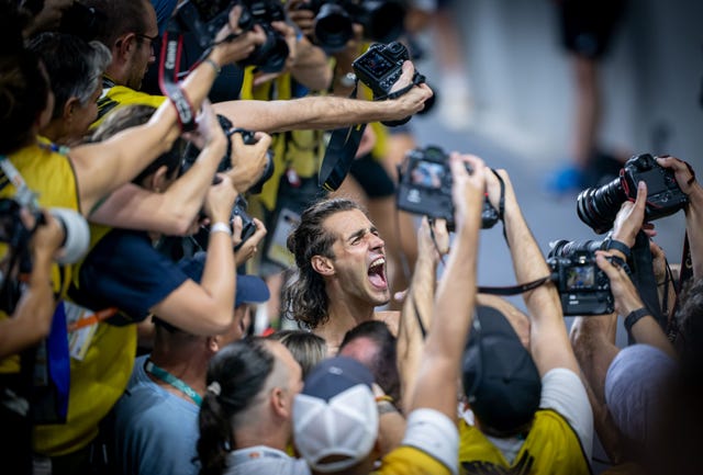 a person with the mouth open surrounded by people holding cameras