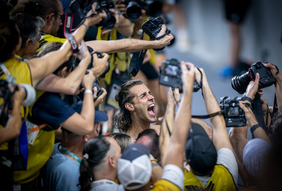 gianmarco tamberi with the mouth open surrounded by people holding cameras