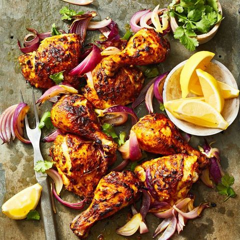 charred tandoori chicken with red onions and lemon slices