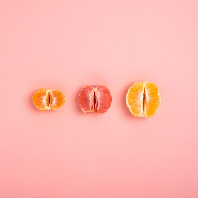 tangerine, grapefruit and orange cut in half on a peach background as a symbol of the vagina and female fertility