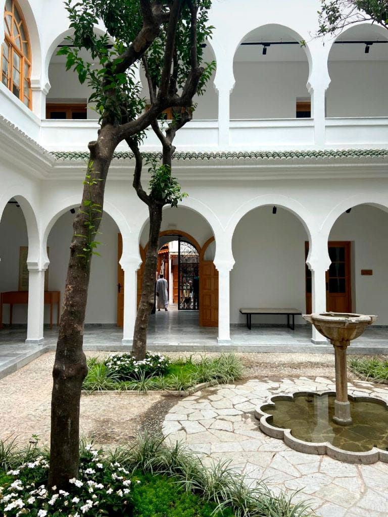 a courtyard with a fountain and trees