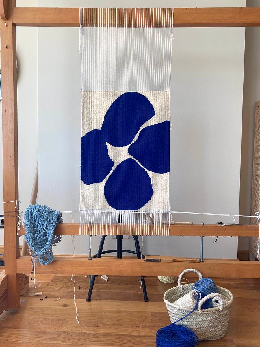 tapiz ines prat en el telar, con flor azul tejida