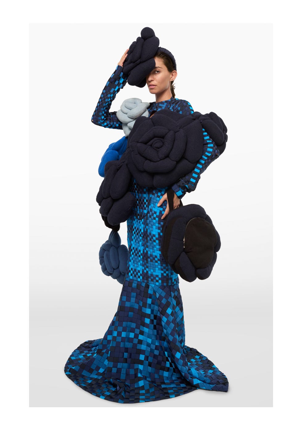 fashion model wearing a unique blue patterned dress adorned with fabric flowers