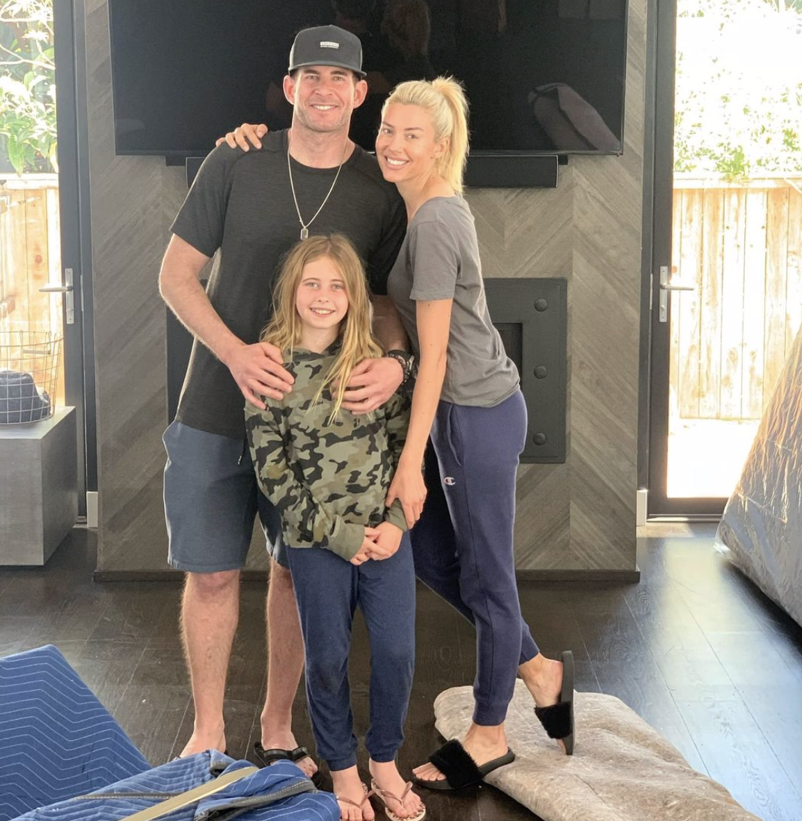 heather rae young, tarek el moussa, and taylor reese standing  in living room