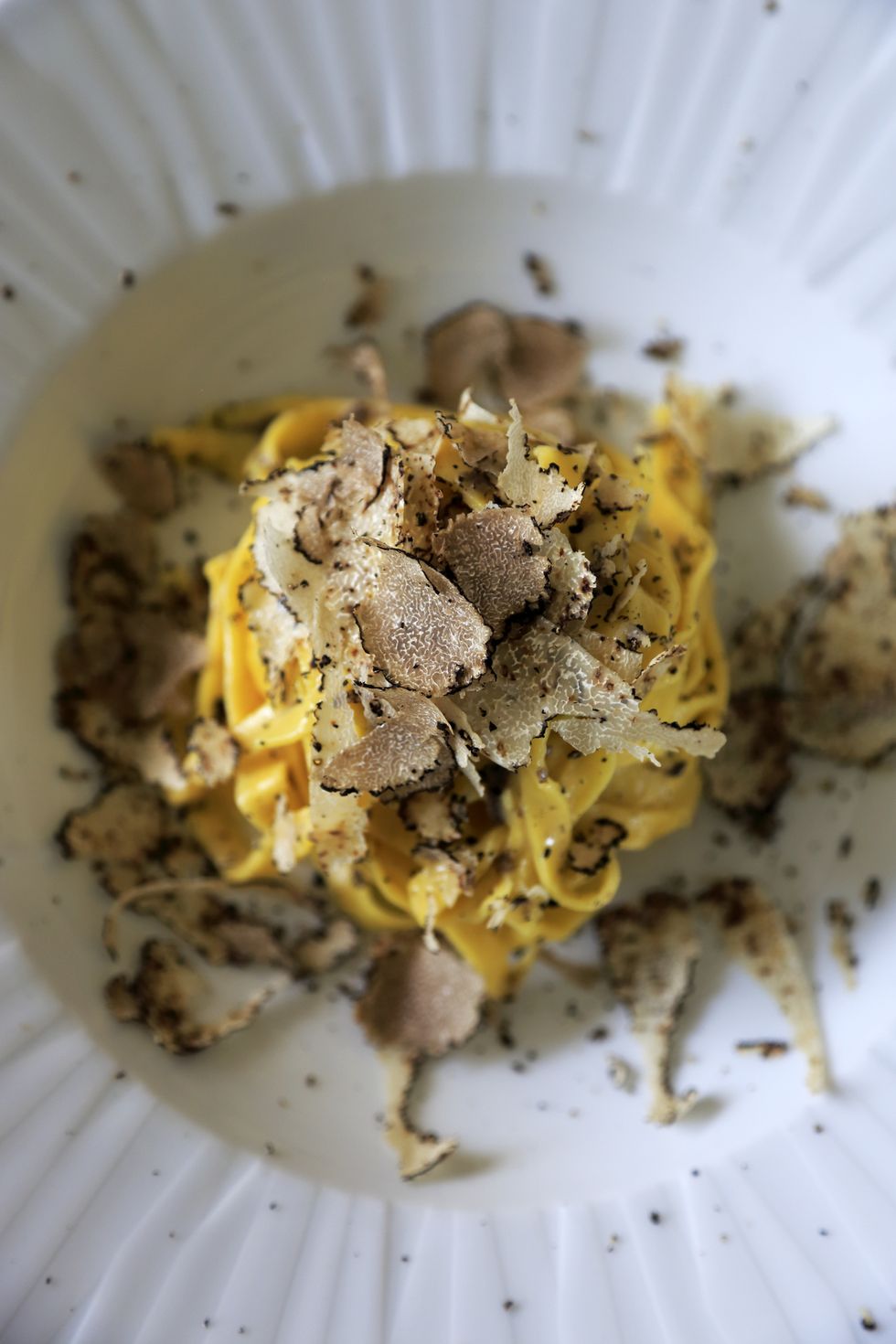 a closed up view of a dish of hand made egg pasta with truffle