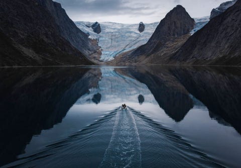 Een plaatselijke visser vaart met zijn boot door de Tasermiutfjord Chu vroeg plaatselijke booteigenaren om hem naar dit gebied te brengen waar hij wandelde en fotos maakte