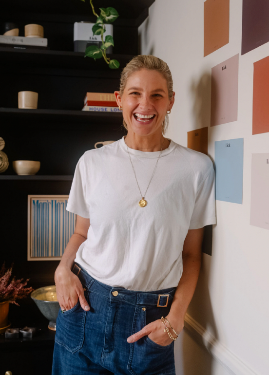 person wearing a white tshirt and blue pants in a cozy indoor setting