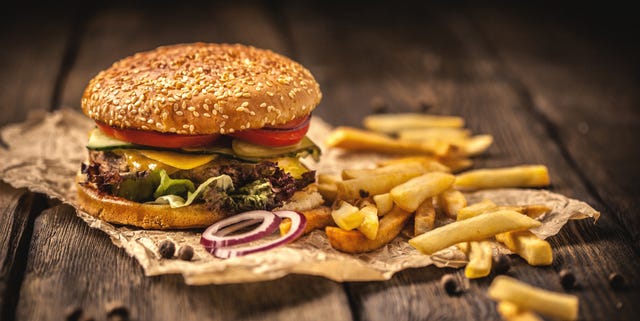 Tasty hamburger with french fries on wooden table