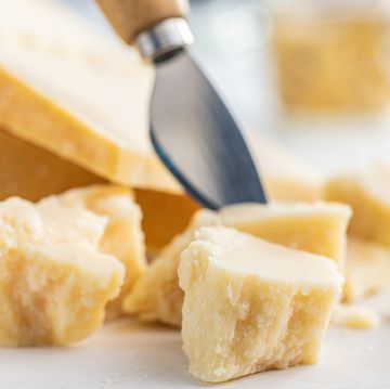 tasty parmesan cheese on white table.