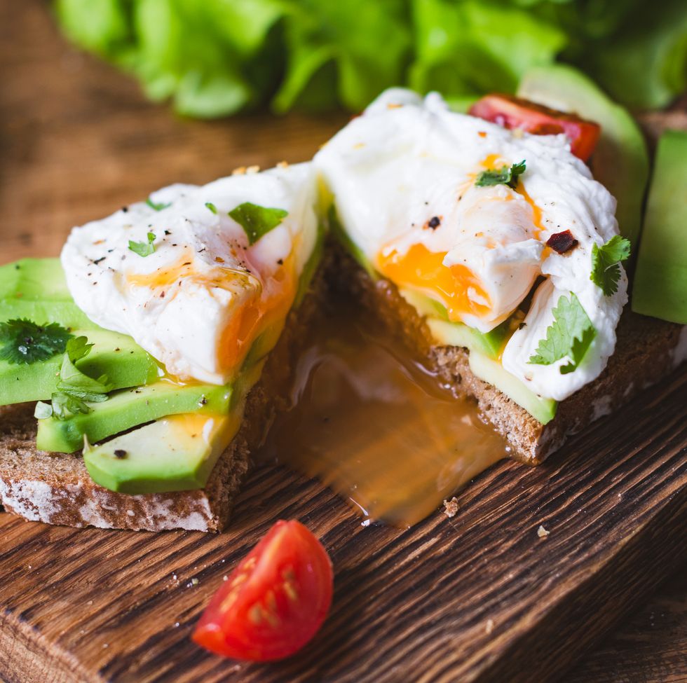 Tasty sandwich with poached egg and avocado