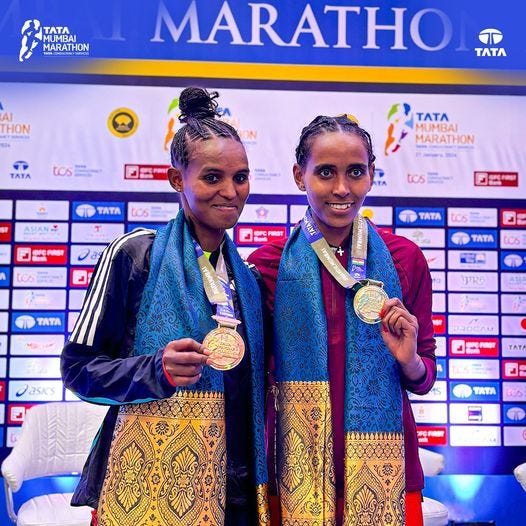 a couple of women holding medals