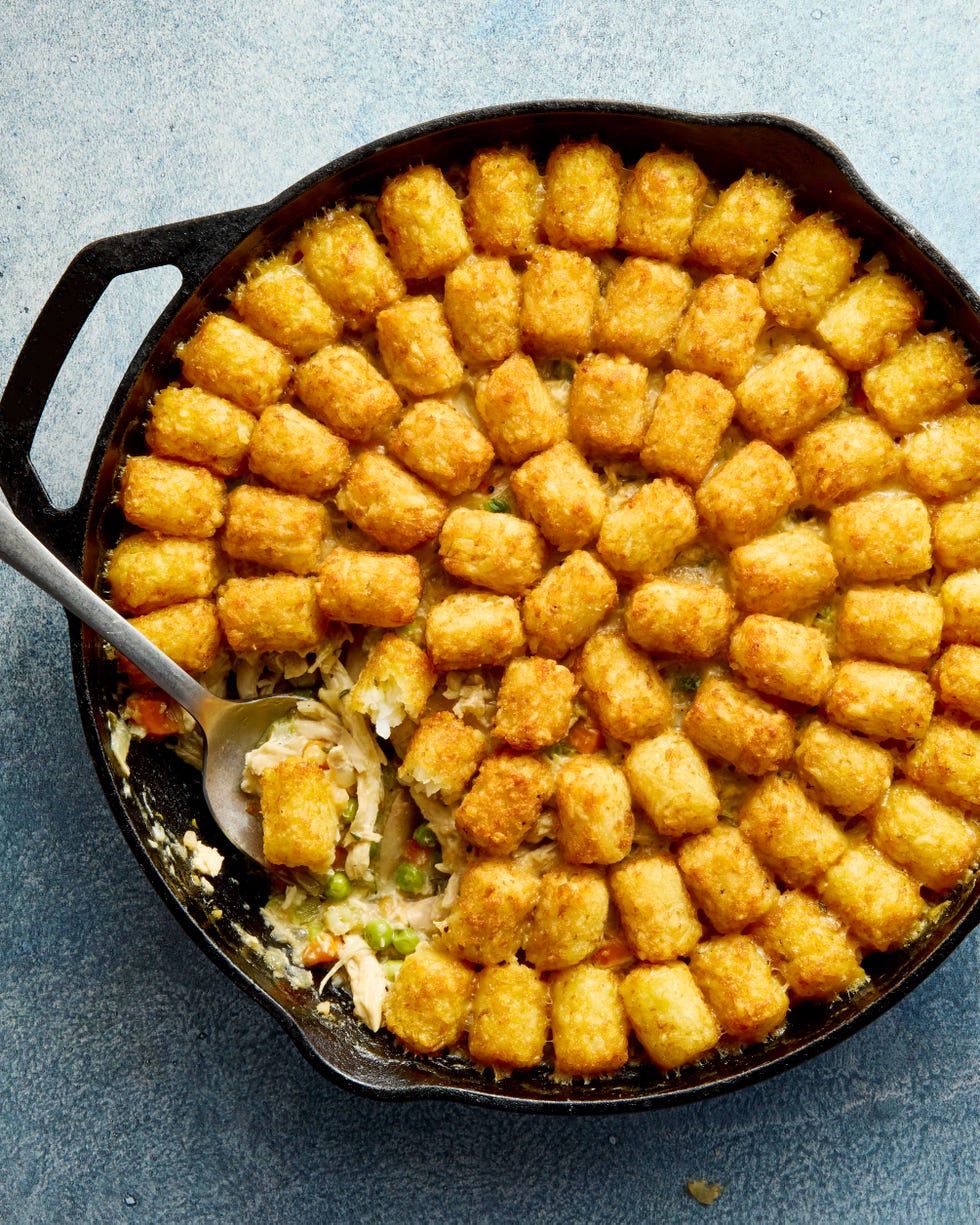 chicken pot pie filling in a skillet topped with tater tots