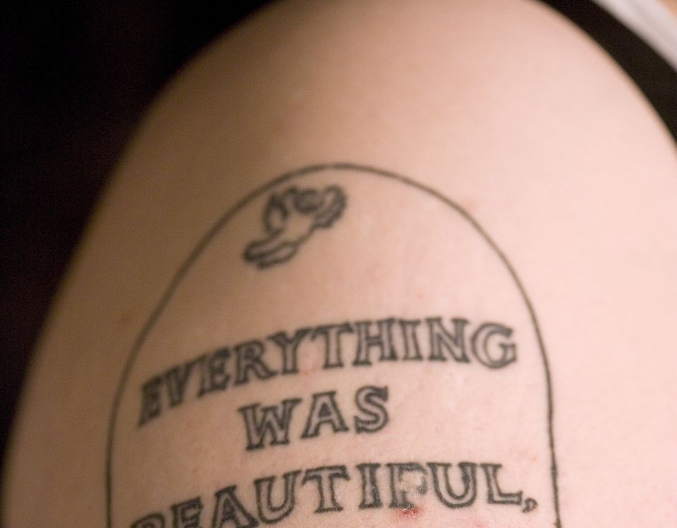 tatoo of headstone on woman's arm, side view, close up