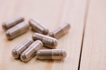 selective focus of scattered pills on wooden table with copy space