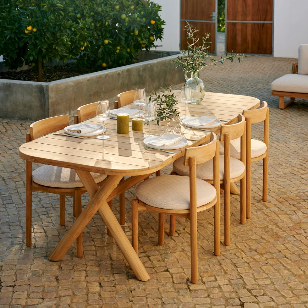 tavolo in legno apparecchiato per pranzo in giardino