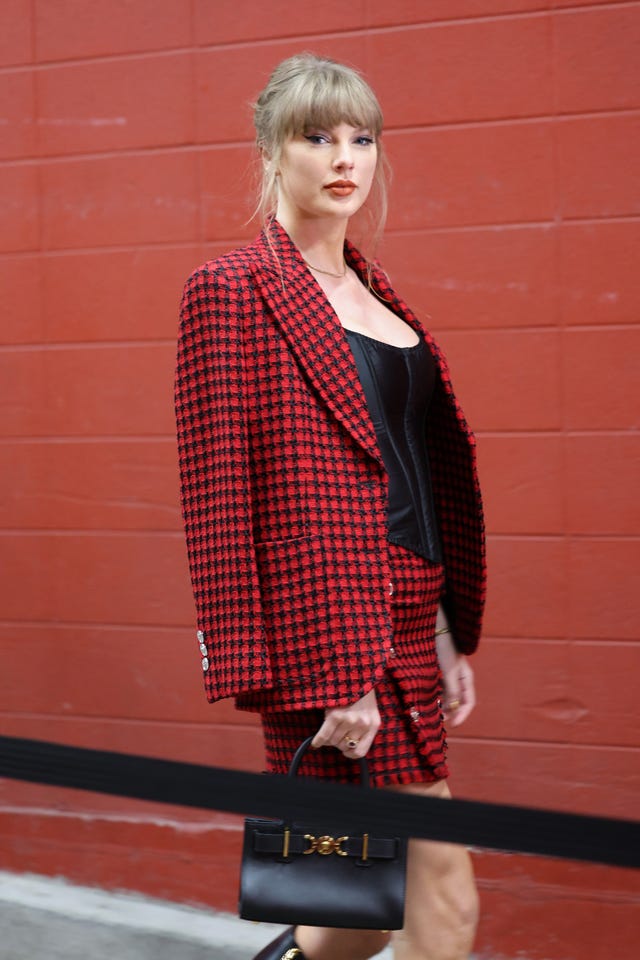 taylor swift with her hair in a chignon hairstyle wearing a red suit