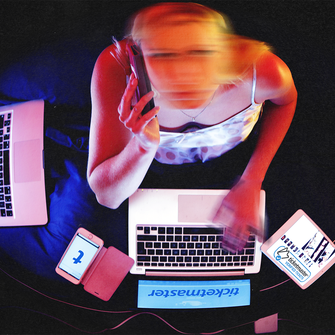 a young woman with a blurry face with two laptops open trying to buy tickets a young woman with a blurry face with two laptops open trying to buy tickets