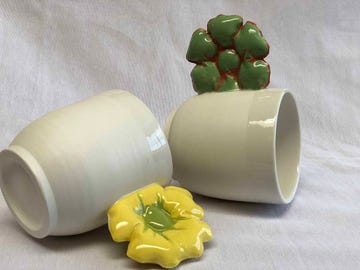 dos tazas de gres con asas en forma de flores