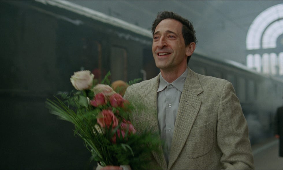 a man holding a bouquet of flowers in a train station