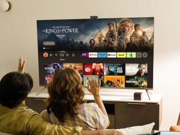 two people watching a smart tv displaying streaming service options