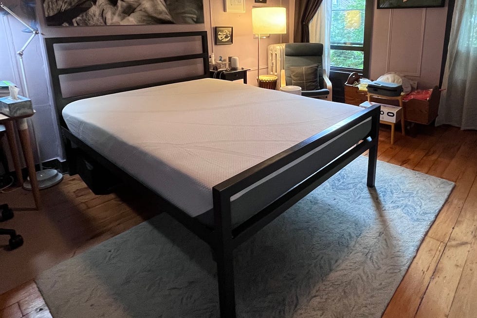tempur-cloud review - setup process a bedroom with a black bed frame and an uncovered white tempur cloud mattress on top during the setup process