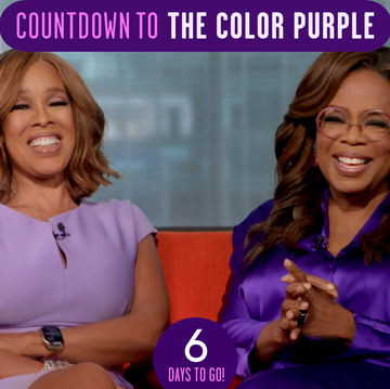 a couple of women sitting on a couch and smiling at the camera