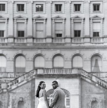 a man and woman posing for a picture in front of a building