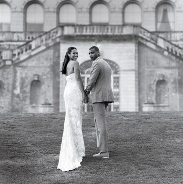 a man and woman posing for a picture in front of a building