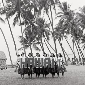 hula dancers on honolulus waikiki beach, form the word hawaii with large letters, to provide a title for those tourists who are about to film the show photo by orlandogetty images