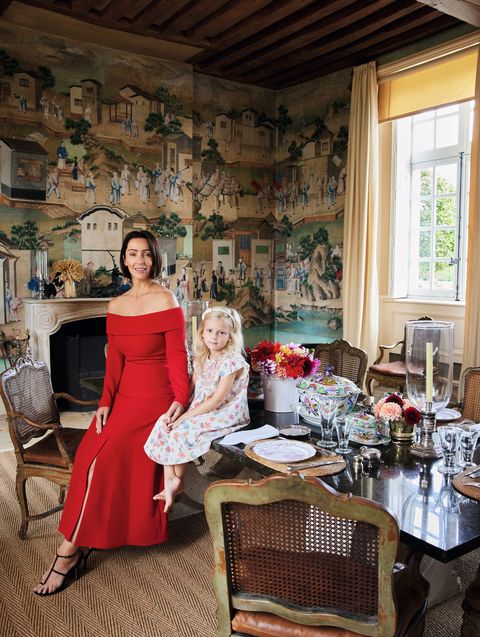 in the dining room, zoë and her daughter inès sit at the dining table, designed by charles sevigny and set with chinoiserie plates from zoë’s home decor brand zdg