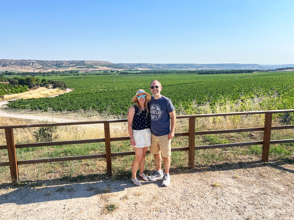 couple standing on a path overlooking a vineyard