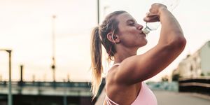 sportieve vrouw drinkt water uit een flesje na haar workout