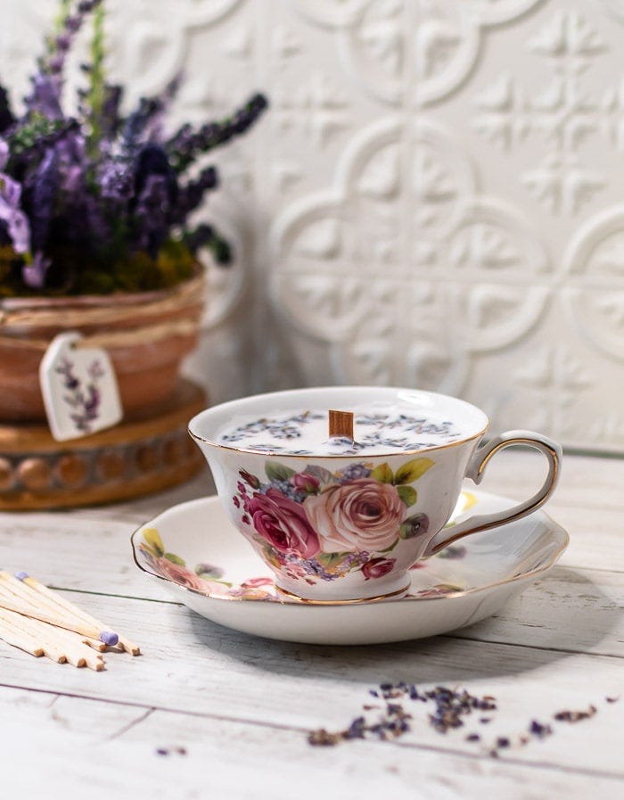 teacup with floral design containing a candle