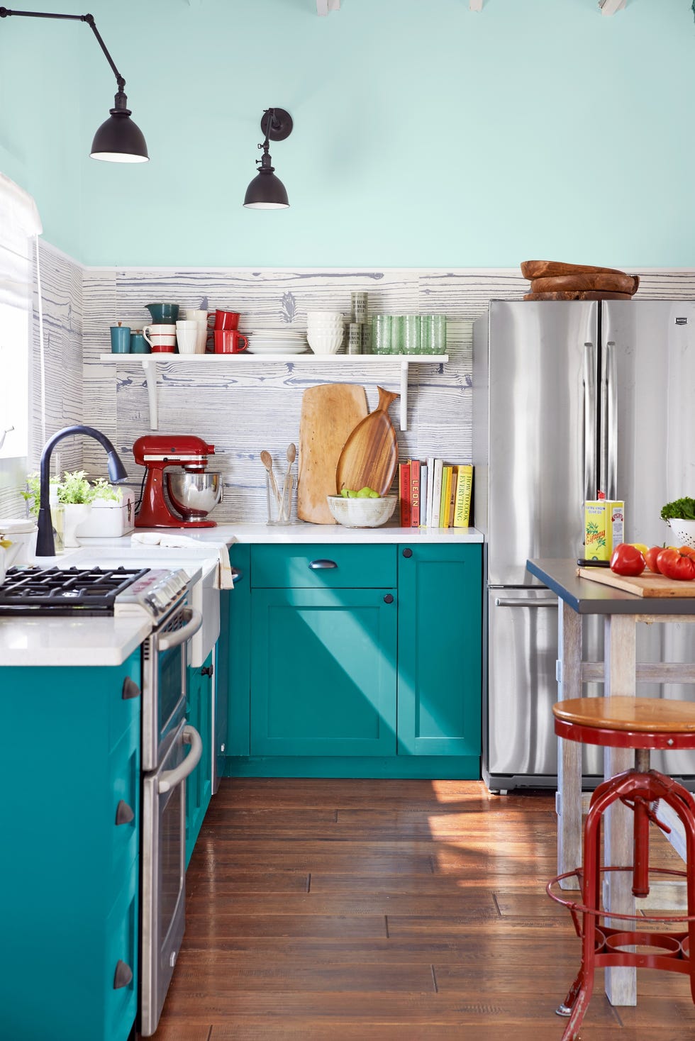 vibrant kitchen with teal cabinets and modern appliances