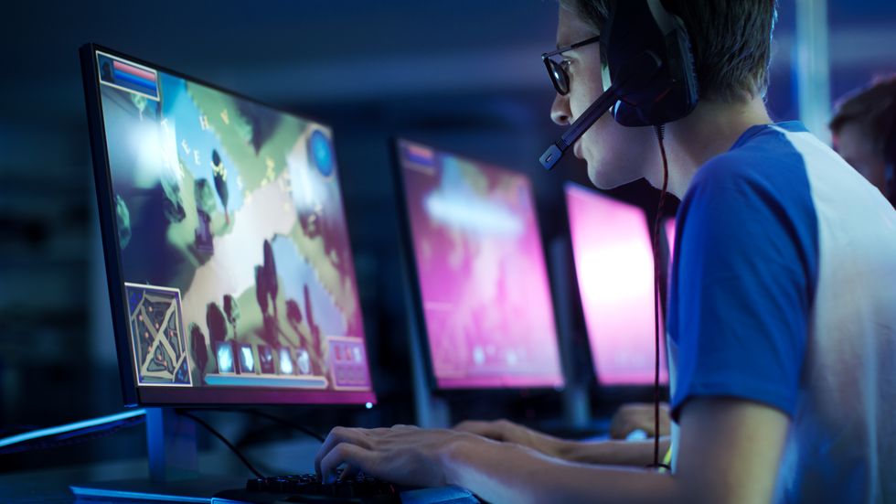 team of professional esport gamers playing in competitive  mmorpg strategy video game on a cyber games tournament they talk to each other into microphones arena looks cool with neon lights
