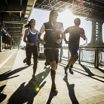 team running together on bridge, new york, usa
