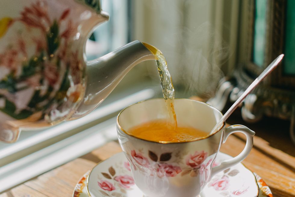 teapot pouring tea in teacup