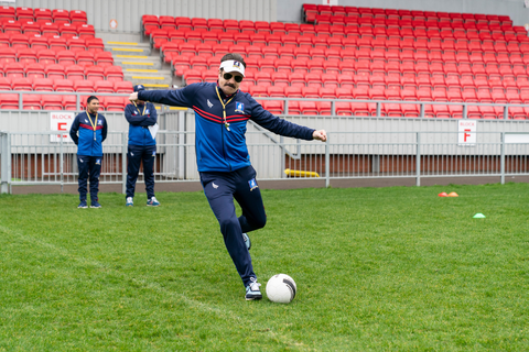 ted lasso kicking a soccer ball