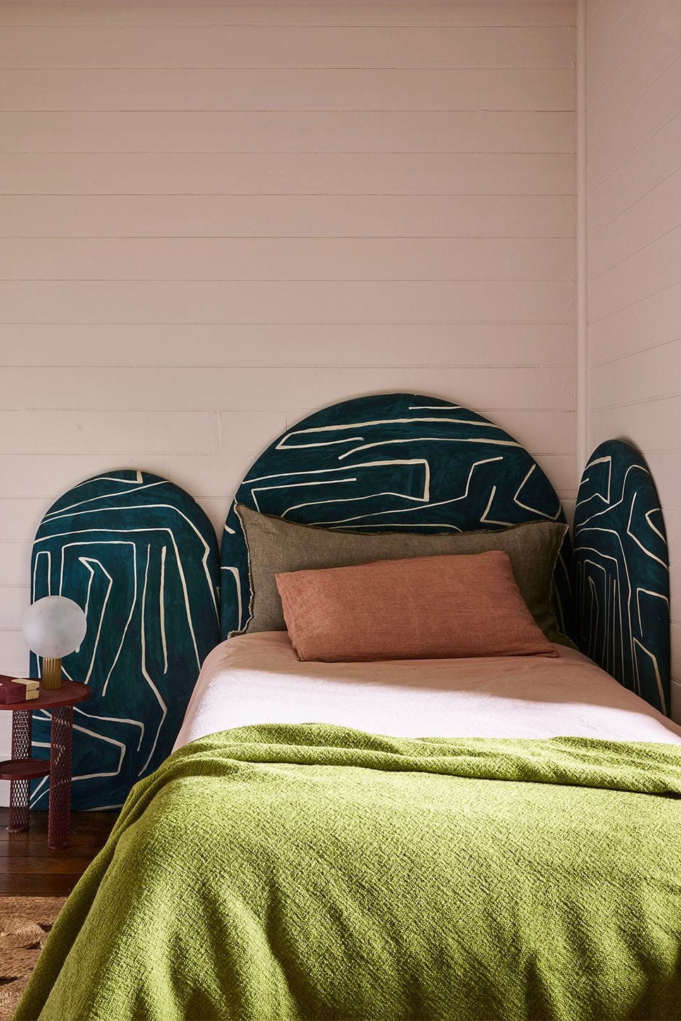 light pink bedroom with teal headboard