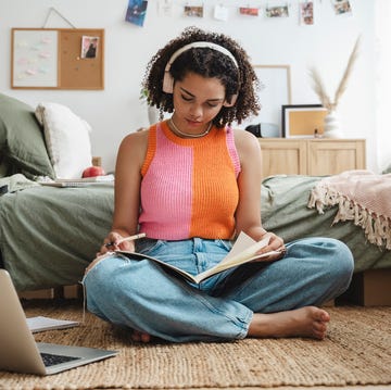 Teenage girl wearing wireless headphones doing homework at home teenage girl wearing wireless headphones doing homework at home