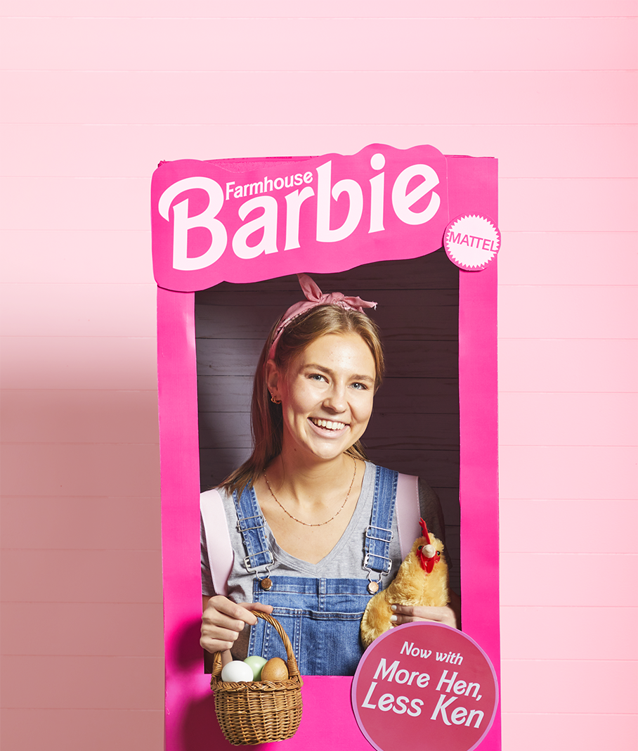 a barbie halloween costume showing a girl from waist up in a barbie themed box that says farmhouse barbie more hen less ken and she's holding a toy chicken and a basket of eggs