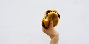 Teenage boy (13-14) holding a bitten hamburger