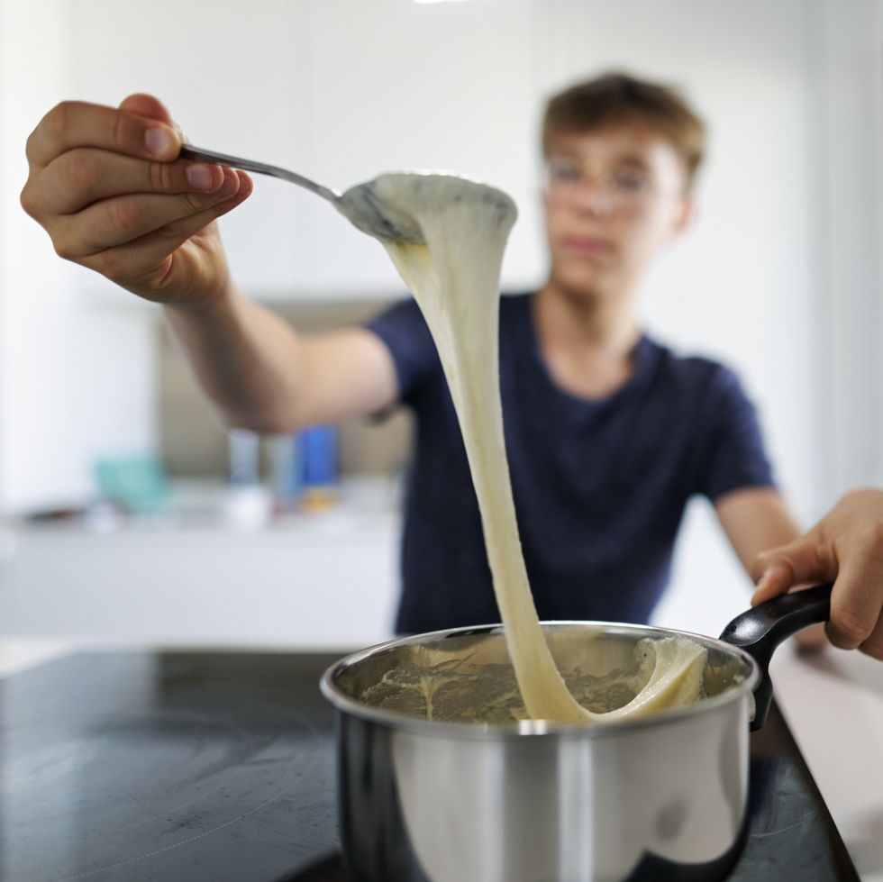 teenage boy is cooking fondue lunch at home