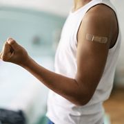teenage boy showing adhesive bandage after vaccination