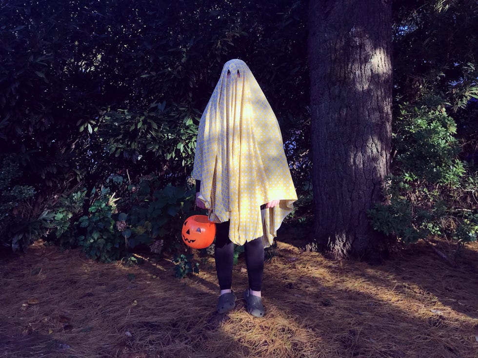 Teenage Boy Wearing a Ghost Costume for Halloween teenage boy wearing a ghost costume for halloween