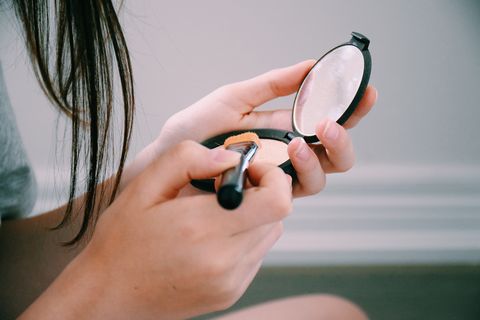 Teenage girl applying make-up