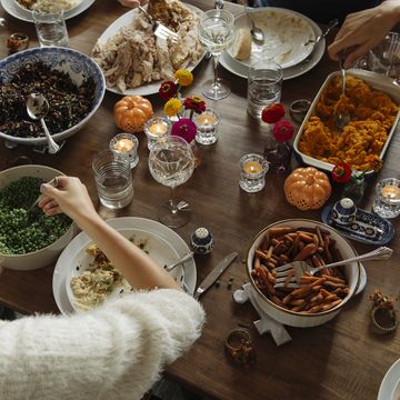 teenage girl having food while sitting at dining table during thanksgiving