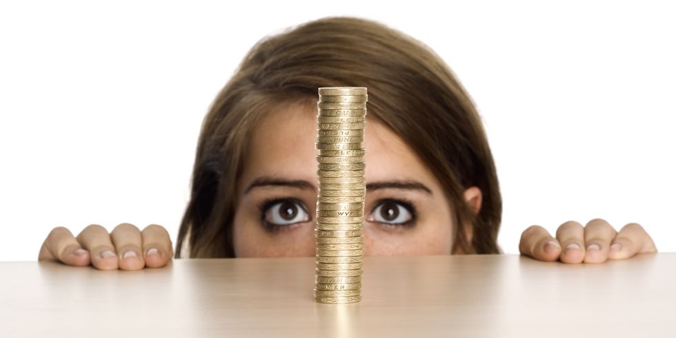 Teenage girl looking at stack of Pound coins