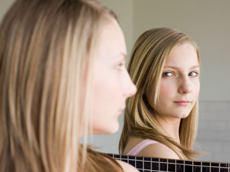 A teenage girl looking in a mirror